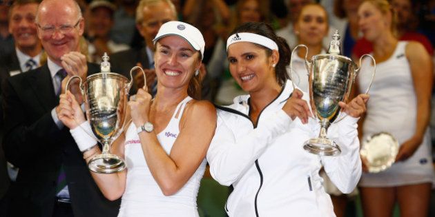 LONDON, ENGLAND - JULY 11: Sania Mirza of India and Martina Hingis of Switzerland celebrate with the trophy after winning the Final Of The Ladies' Doubles against Ekaterina Makarova of Russia and Elena Vesnina of Russia during day twelve of the Wimbledon Lawn Tennis Championships at the All England Lawn Tennis and Croquet Club on July 11, 2015 in London, England. (Photo by Julian Finney/Getty Images)
