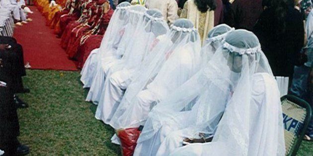 Christians in white wedding gowns, Muslims in red burqas, and Hindus in yellow sarees wait for a marriage ceremony at a mass wedding in Siliguri, India, Sunday Jan. 30, 2000. Some153 couples were married. (AP Photo/Tarun Das)