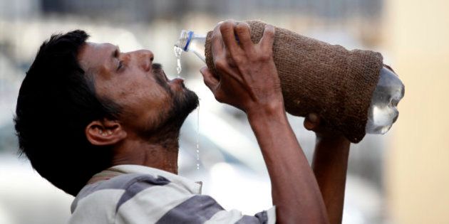 An Indian drinks water from a bottle on a hot summer day in Allahabad, India, Sunday, May 31, 2015. Heat-related conditions, including dehydration and heat stroke, have killed more than 2,000 people since mid-April in the southern Indian states of Andhra Pradesh and Telangana, according to state officials. (AP Photo/Rajesh Kumar Singh)