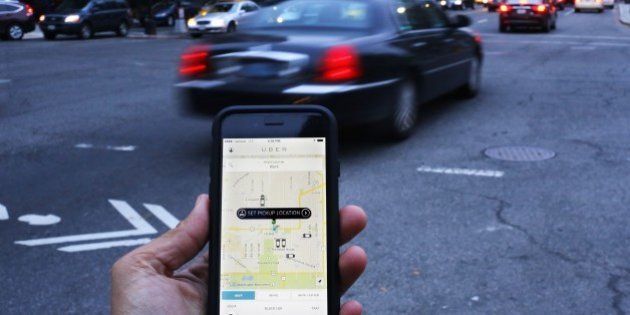 An UBER application is shown as cars drive by in Washington, DC on March 25, 2015. Uber said it was ramping up safety in response to rape allegations against a driver in India and growing concerns about background checks for operators of the popular ride-sharing service. In other cities where Uber operates, critics had complained that a lack of licensing and background checks of drivers could imperil those who use the service. AFP PHOTO/ ANDREW CABALLERO-REYNOLDS (Photo credit should read Andrew Caballero-Reynolds/AFP/Getty Images)
