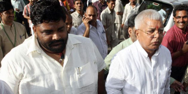 Member of Parliament from India's Rashtriya Janata Dal (RJD) Pappu Yadav (L), who is serving a life sentence in New Delhi's Tihar jail on charges of murdering a Communist Party of India-Marxist leader, walks along with RJD Chief and Indian Railway Minister Lalu Prasad Yadav (R) towards parliament house in New Delhi on July 22, 2008. India's embattled coalition government will go into a parliamentary confidence vote with a tiny advantage but the margin is so tight it has no guarantee of surviving, Indian media say. The Congress party-led coalition government requires a simple majority to survive the vote after its left-wing allies withdrew support earlier this month over their opposition to a nuclear energy agreement with the United States. AFP PHOTO/PRAKASH SINGH (Photo credit should read PRAKASH SINGH/AFP/Getty Images)