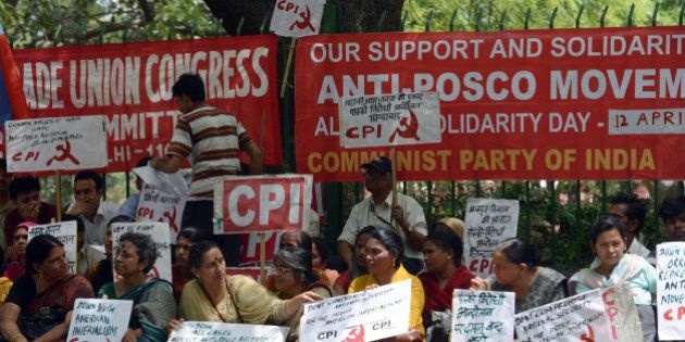 Hundreds of supporters from India's left parties hold anti-US, Korean and Indian government placards against farmland being converted into an industrial development area during a protest against the American-Korean Posco steel plant in New Delhi on April 12, 2013. South Korean steel maker Posco is likely to start work on its much-delayed steel unit in Odisha within a year as the state has transferred a significant chunk of land required for the mega project to the firm, a senior government official said. AFP PHOTO/ RAVEENDRAN (Photo credit should read RAVEENDRAN/AFP/Getty Images)
