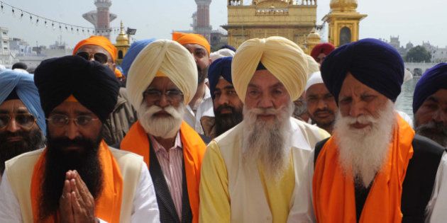 Punjab state Cabinet Ministers Sharanjit Singh Dhillon (L), Sarwan Singh Phillaur (2L) and Tota Singh (R) pay their respects at the Sikh Shrine in Amritsar on March 16, 2012. Punjab Chief Minister Parkash Singh Badal and his cabinet ministers visited the city after taking oath as chief minister for the fifth time during a swearing-in ceremony at Chappar Chiri in Mohali on March 14. AFP PHOTO/NARINDER NANU (Photo credit should read NARINDER NANU/AFP/Getty Images)