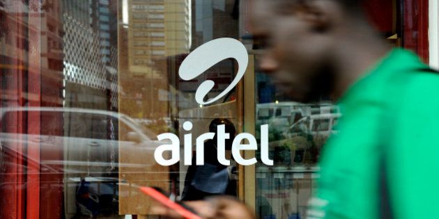 TO GO WITH AFP STORY BY OTTO BAKANOA man with his phone in hand walks past a window branded in an 'Airtel' logo on May 20, 2011 in the Kenyan capital, Nairobi. India will seek to expand its economic footprint in Africa, where its rival China has made major inroads, at the second India-Africa summit next week in Addis Ababa. India's Bharti Airtel -- the world's fifth largest mobile phone company -- acquired the 16-African country unit of Kuwaiti telecom firm, Zain at a cost of $10.7 billion in 2010 when India's imports from Africa were worth $20.7 billion and its exports stood at $10.3 the same year even though China's trade with Africa remains far heftier. AFP PHOTO/Tony KARUMBA (Photo credit should read TONY KARUMBA/AFP/Getty Images)