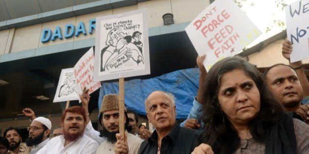 Indian Bollywood director Mahesh Bhatt (3rd R) and Indian activists hold placards during a protest against the Shiv Sena party in Mumbai on July 24, 2014. Television footage on July 23 showed a hardline Hindu nationalist party Shiv Sena lawmaker (member of parliament) apparently trying to force-feed a Muslim man during the fasting month of Ramadan. AFP PHOTO/ PUNIT PARANJPE (Photo credit should read PUNIT PARANJPE/AFP/Getty Images)