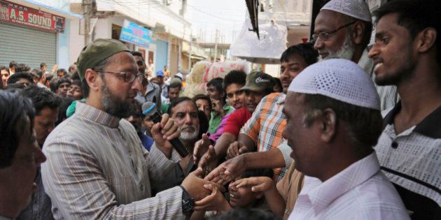 All India Majlis Ittehadul Muslimeen (AIMIM) president Asaduddin Owaisi, left, contesting in the parliamentary elections greets people during his campaign in Hyderabad, India, Friday, April 11, 2014. Indians voted in the crucial third phase of national elections Thursday, with millions going to the polls in the heartland states that are essential to the main opposition Hindu nationalist party's bid to end the 10-year rule of Congress party. (AP Photo/Mahesh Kumar A.)