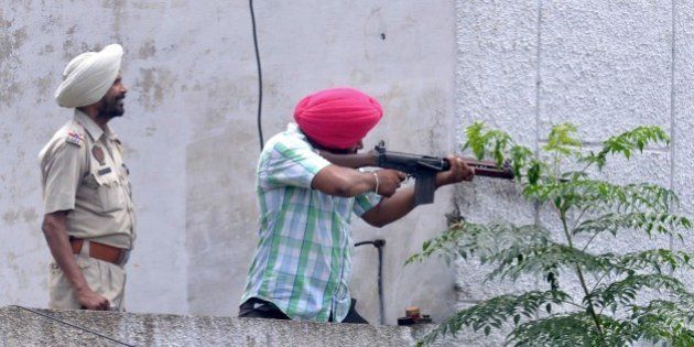 Indian Punjab police personnel fire during an encounter with armed attackers at the police station in Dinanagar town, in the Gurdaspur district of Punjab state on July 27, 2015. Indian security forces were battling an armed attack on a police station near the Pakistan border in which at least five people have been killed. AFP PHOTO/ NARINDER NANU (Photo credit should read NARINDER NANU/AFP/Getty Images)