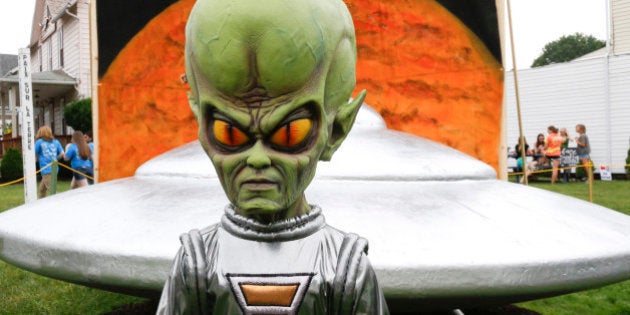 A figure representing a green alien is positioned in front of the permanent flying saucer replica in Mars, Pa. on Friday, June 19, 2015. The small western Pennsylvania town has NASA joining in with a weekend celebration of the Northern Hemisphere Spring Equinox on the planet Mars, marking the start of a new year on the red planet which lasts about 687 Earth days. NASA provided exhibits, booths and outreach activities for the three-day celebration. (AP Photo/Keith Srakocic)