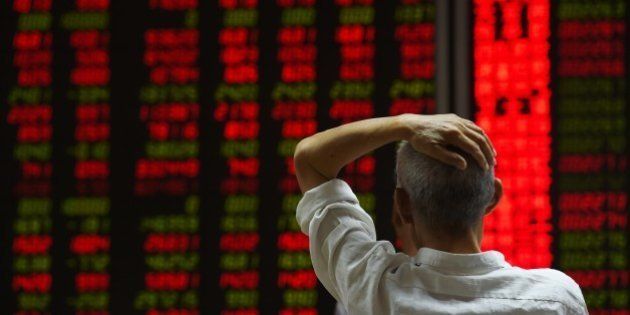 An investor looks at screens showing stock market movements at a securities company in Beijing on July 14, 2015. Hundreds of firms were expected to resume trading again on July 14, adding to the more than 400 that returned July 13, after they were suspended over the past few weeks to prevent a market meltdown. Authorities intervened after the Shanghai index plunged 30 percent in three weeks, wiping trillions of dollars from market capitalisations, spreading contagion in regional markets and raising fears over the potential impact to the real economy. AFP PHOTO / GREG BAKER (Photo credit should read GREG BAKER/AFP/Getty Images)
