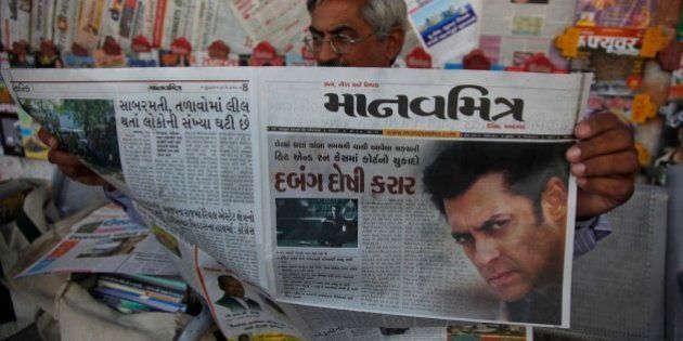 An Indian man reads a newspaper that has the news of Bollywood actor Salman Khanâs court verdict on the front page in Ahmadabad, India, Wednesday, May 6, 2015. One of India's biggest and most popular movie stars, Khan, was sentenced to five years in jail Wednesday on charges of driving a vehicle over five men sleeping on a sidewalk and killing one in a hit-and-run case that has dragged for more than 12 years. (AP Photo/Ajit Solanki)