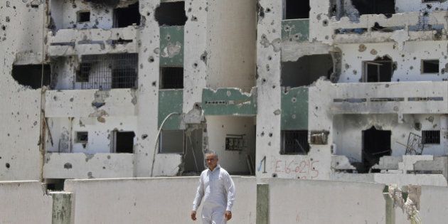 A Libyan man walks past a damaged building in Sirte on July 6, 2012 on the eve of the elections for the General National Congress. Libya's election on July 7, could well bring Islamists to power, but liberals under the leadership of the architects of the revolt that ousted Moamer Kadhafi say they too are confident of a win. AFP PHOTO/MOHAMMED ABED (Photo credit should read MOHAMMED ABED/AFP/GettyImages)