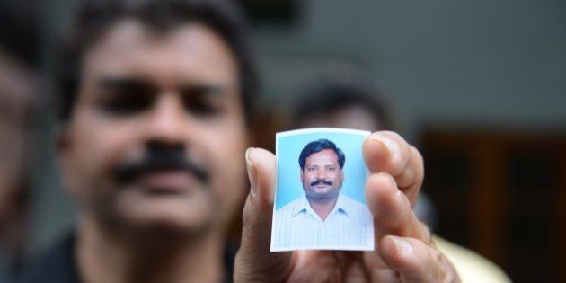 A relative holds up a photograph of Indian national, Balaram, who is thought to have been abducted in Libya, at his residence in Hyderabad on July 31, 2015. Four Indian teachers working in Libya have been 'detained' as they tried to travel home, New Delhi said July 31, sparking fears they are being held by the Islamic State group. India's foreign ministry said the group was detained at a checkpoint around 31 miles (50 kilometres) from Sirte late July 30, and taken to the southern coastal city, which the jihadist group claims to control. AFP PHOTO/ NOAH SEELAM (Photo credit should read NOAH SEELAM/AFP/Getty Images)