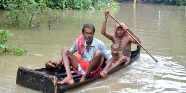 In this photograph taken on August 1, 2015, Indian villagers paddle a small boat through floodwaters in Bherampur Block, Murshidabad District, some 220kms north of Kolkata as the remnants of Cyclone Komen carrying heavy monsoon rains cross the eastern Indian state of West Bengal. Scores have perished in India, Nepal, Pakistan and Vietnam following floods and landslides triggered by heavy seasonal rains. AFP PHOTO/STR (Photo credit should read STRDEL/AFP/Getty Images)
