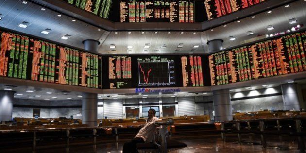 A man sits before electronic boards showing stock movements at the Malaysia Stock Exchange in Kuala Lumpur on July 28, 2015. Asian markets tumbled further dragged down by another massive sell-off in Shanghai a day after the mainland Chinese market's heaviest one-day losses in more than eight years. AFP PHOTO / MANAN VATSYAYANA (Photo credit should read MANAN VATSYAYANA/AFP/Getty Images)