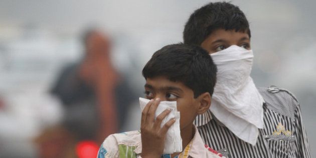 NEW DELHI, INDIA - NOVEMBER 7: Children cover their face to take precaution from the air pollution by a mixture of pollution and fog at NCR region on November 7, 2012 in New Delhi, India. (Photo by Sanjeev Verma/Hindustan Times via Getty Images)