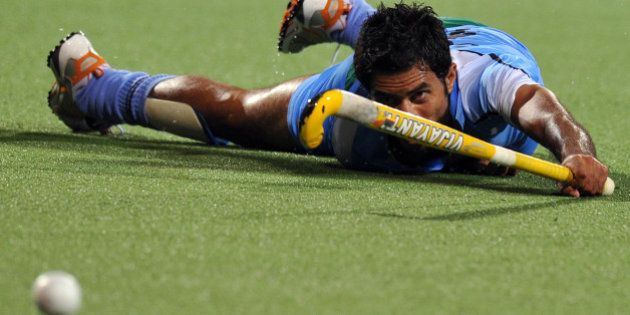 Gurbaj Singh of India watches the ball as he slips on the ground against Malaysia during the field hockey semi-final at the 16th Asian Games in Guangzhou on November 23, 2010. Malaysia defeated India in an extra time by 4-3 and qualified for final. AFP PHOTO / Saeed Khan (Photo credit should read SAEED KHAN/AFP/Getty Images)
