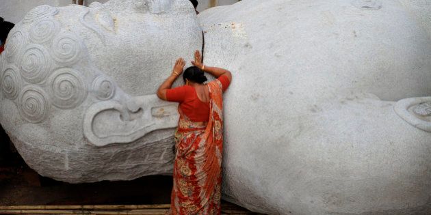 In this Wednesday, June 9, 2010 photograph, a woman worships a 41 foot (12.5 meters) tall statue of Jain sage Lord Bahubali carved out of a single block of granite in Sihor, 200 kilometers (125 miles) from Ahmadabad, India. Jainism, which originated in India, has nearly 4 million followers in the country. (AP Photo/Ajit Solanki)