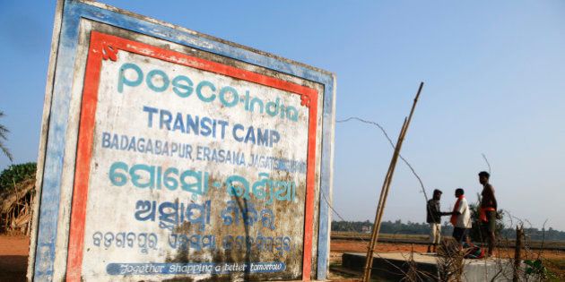 Signage for the Posco India Transit Camp, where families relocated from the site of a proposed Posco steel plant have been provided temporary shelter, stands in Badagabapur, Odisha, India, on Sunday, Jan. 19, 2014. Posco may soon start construction on a $12 billion steel complex in India first proposed in 2005 as Prime Minister Manmohan Singh speeds up the approval process for the nations biggest foreign investment. Photographer: Prashanth Vishwanathan/Bloomberg via Getty Images