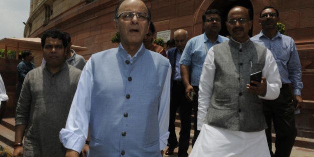 NEW DELHI, INDIA - JULY 21: Union Finance Minister Arun Jaitley (C) with BJP National Media Convener Shrikant Sharma (L) and Rajya Sabha MP Vijay Goel going to address the media after adjourned Rajya Sabha on the first day of monsoon session at Parliament House on July 21, 2015 in New Delhi, India. The monsoon session of Parliament started on a stormy note on Tuesday with Congress and other opposition parties stalling proceedings, demanding the resignation of External Affairs Minister Sushma Swaraj and two Chief Ministers over the Lalit Modi controversy and the Vyapam scam. (Photo by Sonu Mehta/Hindustan Times via Getty Images)