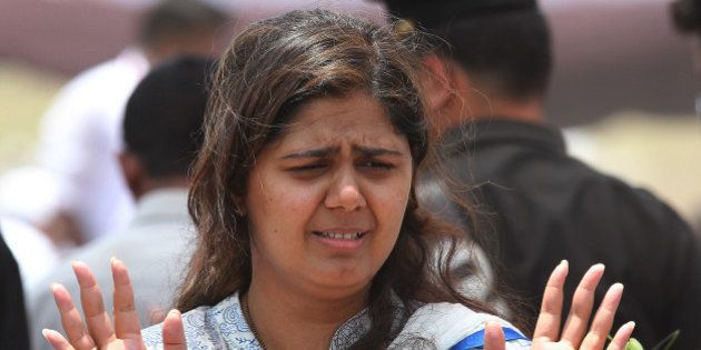 BEED, INDIA - JUNE 4: Daughter Pankaja Munde of late BJP leader Gopinath Munde during his funeral at Parali on June 4, 2014 in Beed, India. Munde, 64, Union Rural Development Minister, was yesterday killed in a road accident in Delhi while he was on way to Parli for a felicitation following his own and BJP's resounding victory in the Lok Sabha elections, which saw him re-elected for a second time from Beed. (Photo by Anshuman Poyrekar/Hindustan Times via Getty Images)