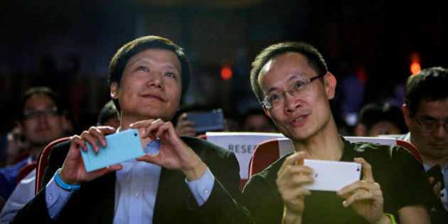Billionaire Lei Jun, chairman and chief executive officer of Xiaomi Corp., left, and Bin Lin, president and co-founder, hold their smartphones during a news conference in New Delhi, India, on Thursday, April 23, 2015. Xiaomi unveiled the multi-language Mi 4i smartphone for India as China's largest smartphone maker adds new products to its biggest export market. Photographer: Kuni Takahashi/Bloomberg via Getty Images