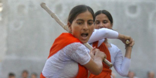 Madhu, a member of Durga Vahini, the womens wing of Hindu nationalist group Rashtriya Swayamsevak Sangh (RSS) or National Volunteers Association, performs a self-defense exercise with a stick on the outskirts of Jammu, India, Friday, June 18, 2004. The RSS organized a seven-day camp for self-defense training for its women cadres belonging to militancy-affected areas that ended Friday. (AP Photo/Channi Anand)