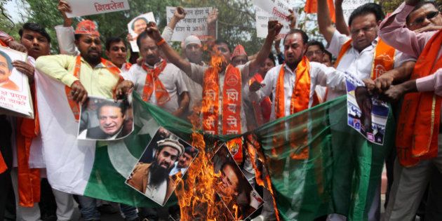Hindu right-wing Shiv Sena activists burn a Pakistani flag along with posters of Pakistani Prime Minister Nawaz Sharif and suspected mastermind of the deadly Mumbai attacks in 2008 Zaki-ur-Rehman Lakhvi, center, after Lakhvi was released on bail by a Pakistani court, in New Delhi, India, Saturday, April 11, 2015. The release of Lakhvi, who has been held since his arrest in 2009, drew expressions of concern from both India and the United States. Lakhvi has been described as the operations chief for Lashkar-e-Taiba, the group blamed for the series of bombings and shootings in the heart of the Mumbai that killed 166 people. (AP Photo/Altaf Qadri)