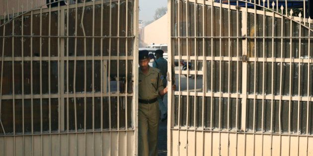 FILE- In this March 11, 2013 file photo, an Indian police officer prepares to close one of the gates at Tihar Jail, the largest complex of prisons in South Asia, in New Delhi, India. Indiaâs Tihar Jail is a land of bakeries and carpentry shops, where inmates compete in music contests, take classes and perform intensive Buddhist meditation as part of their rehabilitation. Tihar Jail is also a vast, overcrowded facility, crammed with people awaiting trial who sleep on concrete floors, face daily threats from other prisoners and are shaken down for bribes from their poorly paid jailers, according to human rights lawyers and former inmates there. The two sides of Indiaâs most famous jail emerged this week when a man accused in the notorious rape of a woman aboard a New Delhi bus was found dead in his cell, either a suicide, according to jail officials, or a victim of foul play, according to his family. (AP Photo/Saurabh Das)