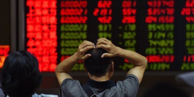 An investor looks at screens showing stock market movements at a securities company in Beijing on July 14, 2015. Hundreds of firms were expected to resume trading again on July 14, adding to the more than 400 that returned July 13, after they were suspended over the past few weeks to prevent a market meltdown. Authorities intervened after the Shanghai index plunged 30 percent in three weeks, wiping trillions of dollars from market capitalisations, spreading contagion in regional markets and raising fears over the potential impact to the real economy. AFP PHOTO / GREG BAKER (Photo credit should read GREG BAKER/AFP/Getty Images)