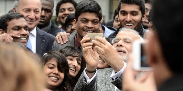 Indian Prime Minister Narendra Modi (C) takes a selfie with a delegation of Indian people studying in the French Midi-Pyrenees region next to French Foreign Affairs Minister Laurent Fabius (L) as he visits the National center for space studies (CNES) on April 11, 2015 in Toulouse. Modi wraps up his two-day trip to France with a visit to the Airbus headquarters after he said on the eve he had asked France to supply his air force with 36 Rafale fighter jets, after years of wrangling over the deal. AFP PHOTO / REMY GABALDA (Photo credit should read REMY GABALDA/AFP/Getty Images)
