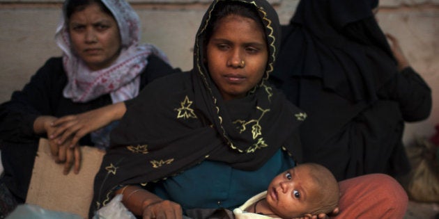 Burmese refugees from the Rohingya community, a predominantly Muslim sect in Burma, take refuge on a street near the United Nations High Commission for Refugees (UNHCR) office in New Delhi on May 6, 2012. Eight hundred Burmese refugees have set up a temporary camp near the UNHCR office in South Delhi since April 9, 2012. The UNHCR has issued them asylum seeker cards but they have been demanding refugee status. AFP PHOTO/ Andrew Caballero-Reynolds (Photo credit should read Andrew Caballero-Reynolds/AFP/GettyImages)