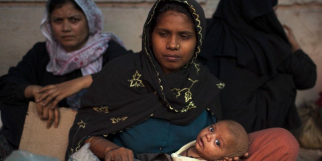 Burmese refugees from the Rohingya community, a predominantly Muslim sect in Burma, take refuge on a street near the United Nations High Commission for Refugees (UNHCR) office in New Delhi on May 6, 2012. Eight hundred Burmese refugees have set up a temporary camp near the UNHCR office in South Delhi since April 9, 2012. The UNHCR has issued them asylum seeker cards but they have been demanding refugee status. AFP PHOTO/ Andrew Caballero-Reynolds (Photo credit should read Andrew Caballero-Reynolds/AFP/GettyImages)