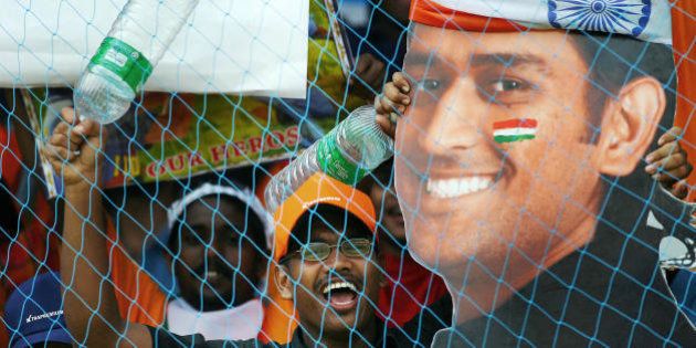 Kochi, INDIA: Indian supporters wave a cut out of player Mahendra Singh Dhoni during the fourth One-Day International match between India and England at The Jawaharlal Nehru Stadium, in Kochi, 06 April 2006. India won by 4 wickets to clinch the seven-match one-day series 4-0. AFP PHOTO/Christophe ARCHAMBAULT (Photo credit should read CHRISTOPHE ARCHAMBAULT/AFP/Getty Images)