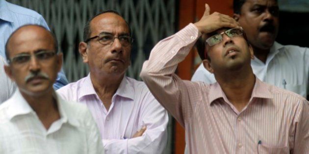 MUMBAI, INDIA - AUGUST 24: Anxious onlookers watch share prices on a screen outside the Bombay Stock Exchange on August 24, 2015 in Mumbai, India. Sensex crashed over 1700 points or 6.22 per cent in pre-close trade with the investor wealth down by over Rs. 7 lakh crore with nearly Rs. 4 lakh crore lost in an hour. (Photo by Kunal Patil/Hindustan Times via Getty Images)