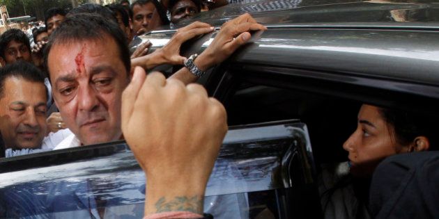 Bollywood star Sanjay Dutt, second left, arrives with wife Manyata, right, to surrender before a court in Mumbai, India, Thursday, May 16, 2013. Dutt has been sentenced to five years in prison for a 1993 weapons conviction linked to a deadly terror attack in Mumbai that killed 257 people. The 53-year-old actor served 18 months in jail before being released on bail in 2007 pending an appeal. The Supreme Court reduced his prison sentence to five years from the six-year term initially handed down. (AP Photo/Rajanish Kakade)