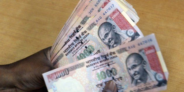 An Indian forex dealer counts INR 1000 currency notes in Mumbai on August 25, 2015. The Indian rupee recovered by 26 paise to reach 66.39 against the dollar on the Interbank Foreign Exchange in early trade. Dealers said fresh selling of the US currency by exporters and banks, the weakening of the dollar overseas and gains across stock markets supported the domestic currency. AFP PHOTO/ INDRANIL MUKHERJEE (Photo credit should read INDRANIL MUKHERJEE/AFP/Getty Images)