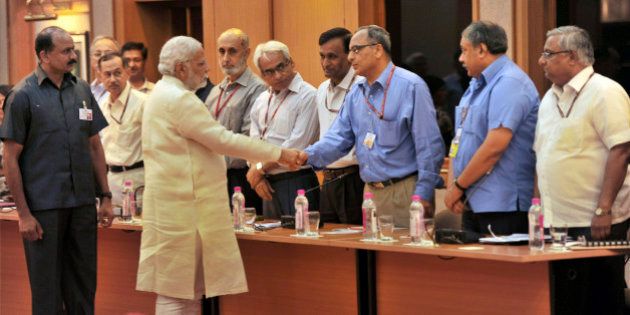 In this June 4, 2014 photo, Indian Prime Minister Narendra Modi, second left in front, interacts with bureaucrats before their meeting in New Delhi, India. The top civil servants in in India's labyrinthine bureaucracy these days, are spending their evenings paging through dictionaries, frantically looking up words. The dictionary searches stem from an order by new Prime Minister Modi: All official work must now be done in Hindi, the language spoken by about 45 percent of India's 1.2 billion people. In a country with as many as 22 official languages many question Hindi's dominance. (AP Photo)
