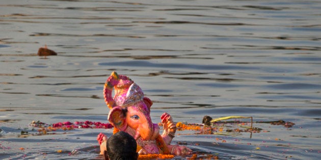 An Indian Hindu devotee immerses an idol of the elephant-headed Hindu God Ganesh into the river Yamuna, in New Delhi, India, Monday, Sept. 8, 2014. Every year millions of devout Hindus immerse Ganesh idols into oceans and rivers in the ten-day long Ganesh Chaturthi festival that celebrates the birth of Ganesh. (AP Photo /Manish Swarup)