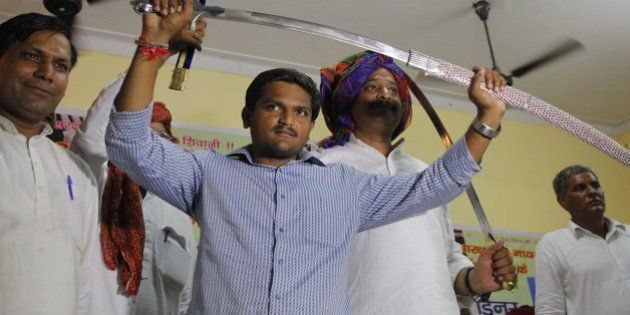 NEW DELHI, INDIA - AUGUST 30: Hardik Patel, Convener of Patidar Anamat Andolan Samiti (PAAS) being felicitated by Gurjar Community at Kotla Village, Gurjar Bhawan near Patparganj, on August 30, 2015 in New Delhi, India. Patel announced that he won't allow any political party to join his agitation and he wants to turn the stir into a national movement. He strongly defended his demand for reservation for Patels or Patidars, saying they are not getting jobs due to reservation. He said, 'We are not here to meet any ministers. Political parties are not welcome in the agitation.' (Photo by Arvind Yadav/Hindustan Times via Getty Images)