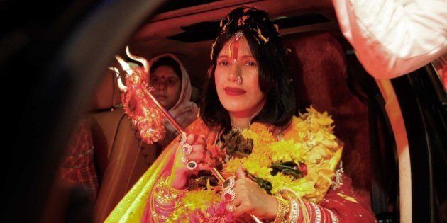 MUMBAI, INDIA - AUGUST 27: (file photo) Radhe Maa, self-proclaimed Godwoman, visits Siddhivinayak Temple, Prabhadevi, on August 27, 2012 in Mumbai, India. Radhe Maa has been accused of dowry harassment by a woman, who has filed an FIR or police complaint in Mumbai. The woman has said that her husband's family tortured her on the Godwoman's advice and forced her to serve Radhe Maa, do chores for her and give her massages. Radhe Maa's real name is Sukhvinder Kaur. She was born on 4 April 1965 in Dorangala village of Gurdaspur district in Punjab. Her followers state that she was drawn to spirituality as a child, and spent a lot of time at the Kali temple in her village. However, according to the people of her village, she did not show any spiritual leanings as a child. At the age of 23, she became a disciple of Mahant Ram Deen Das of 1008 Paramhans Bagh Dera Mukerian in Hoshiarpur district. Ram Deen Das oversaw her deeksha (initiation ceremony), and gave her the title Radhe Maa. She is usually seen in glittering red bridal wear, heavy jewellery and layers of make-up. Thick garlands and a trident complete the picture. She used to stitch clothes to support her husband's small income. (Photo by Vijayanand Gupta/Hindustan Times via Getty Images)