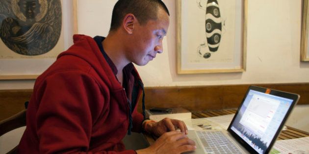 Jamyang Palden, a 30-year-old Tibetan Buddhist monk uses his laptop to access his email at a cafe with WiFi connection in Dharmsala, India, Monday, Nov. 10, 2014. Buffeted by constant cyberattacks, monks like Palden are being taught a new Information Age creed: âDetach from Attachments.â The Internet safety slogan is an example of how human rights defenders are seeking creative ways to protect activists from electronic espionage. (AP Photo/Ashwini Bhatia)