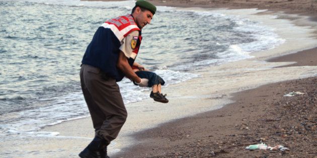 ADDS IDENTIFICATION OF CHILD A paramilitary police officer carries the lifeless body of Aylan Kurdi, 3, after a number of migrants died and a smaller number were reported missing after boats carrying them to the Greek island of Kos capsized, near the Turkish resort of Bodrum early Wednesday, Sept. 2, 2015. The family â Abdullah, his wife Rehan and their two boys, 3-year-old Aylan and 5-year-old Galip â embarked on the perilous boat journey only after their bid to move to Canada was rejected. The tides also washed up the bodies of Rehan and Galip on Turkey's Bodrum peninsula Wednesday, Abdullah survived the tragedy. (AP Photo/DHA) TURKEY OUT