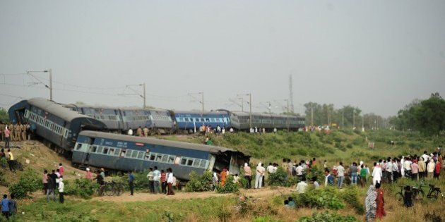 Indian bystanders look at the coaches of the derailed Muri Express train near Sirathu some 65kms from Allahabad on May 25, 2015. Two passengers have been killed after seven coaches of the Muri Express derailed near Sirathu in the northern state of Uttar Pradesh. AFP PHOTO/SANJAY KANOJIA (Photo credit should read Sanjay Kanojia/AFP/Getty Images)