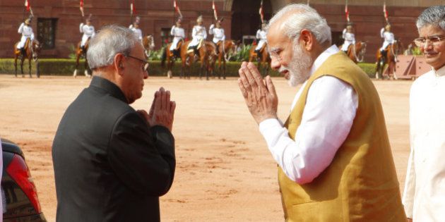 NEW DELHI, INDIA - AUGUST 26: Prime Minister Narendra Modi and President Pranab Mukherjee greet each other during the ceremonial reception of Seychelles President James Alix Michel at Rashtrapati Bhavan on August 26, 2015 in New Delhi, India. India and Seychelles on Wednesday exchanged five documents, including one on exchanging tax information and a Memorandum of Understanding (MoU) for providing a Dornier maritime surveillance aircraft. (Photo by Arvind Yadav/Hindustan Times via Getty Images)