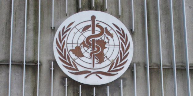 In this photo taken Wednesday, March 11, 2015, a man walks past the logo of the World Health Organization (WHO) at its headquarters building in Geneva, Switzerland. In a delay that some say may have cost lives, the World Health Organization resisted calling the Ebola outbreak in West Africa a public health emergency until the summer of 2014, two months after staff raised the possibility and long after a senior manager called for a drastic change in strategy, The Associated Press has learned. (AP Photo/Raphael Satter)