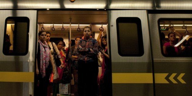 Indian women are framed in the doorway as they travel in the carriage reserved for women on the metro in New Delhi on July 3, 2015. AFP PHOTO/ Anna ZIEMINSKI (Photo credit should read ANNA ZIEMINSKI/AFP/Getty Images)