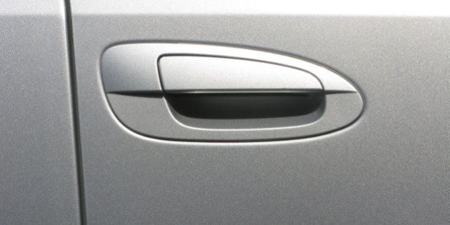 A silver automobile's door handle section