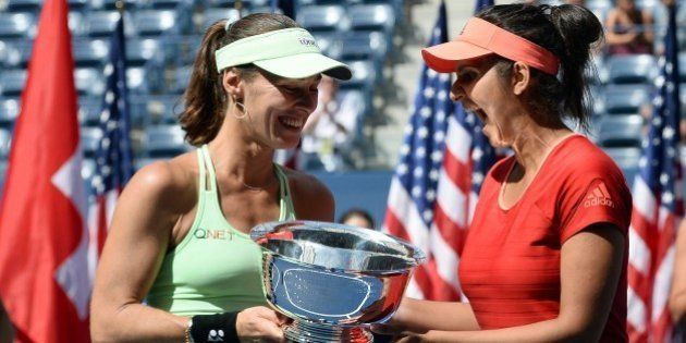 Sania Mirza (R) of India and her teammate Martina Hingis of Switzerland celebrate with their trophy after defeating Casey Dellacqua of Australia and Yaroslava Shvedova of Kazakhstan during their 2015 US Open Women's Double final match at the USTA Billie Jean King National Tennis Center in New York on September 13, 2015. AFP PHOTO/JEWEL SAMAD (Photo credit should read JEWEL SAMAD/AFP/Getty Images)