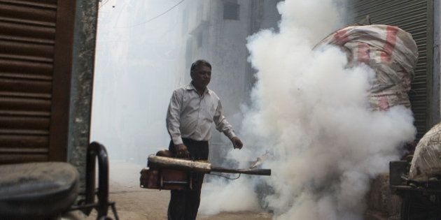 Indian labourer fumagates an alley to prevent dengue