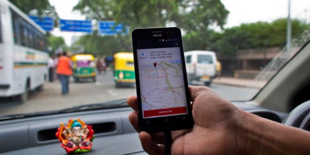 An Indian cab driver displays the city map on a smartphone provided by Uber as he drives in New Delhi, India, Friday, July 31, 2015. Ride-hailing service Uber has announced a $1 billion investment for the Indian market for the next nine months as it hopes to expand services and products, news reports said Friday. (AP Photo/Saurabh Das)